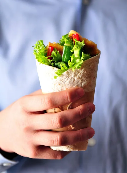 Tortilla con pollo a la parrilla, pimiento rojo, pepino y lechuga en la mano de un adolescente —  Fotos de Stock