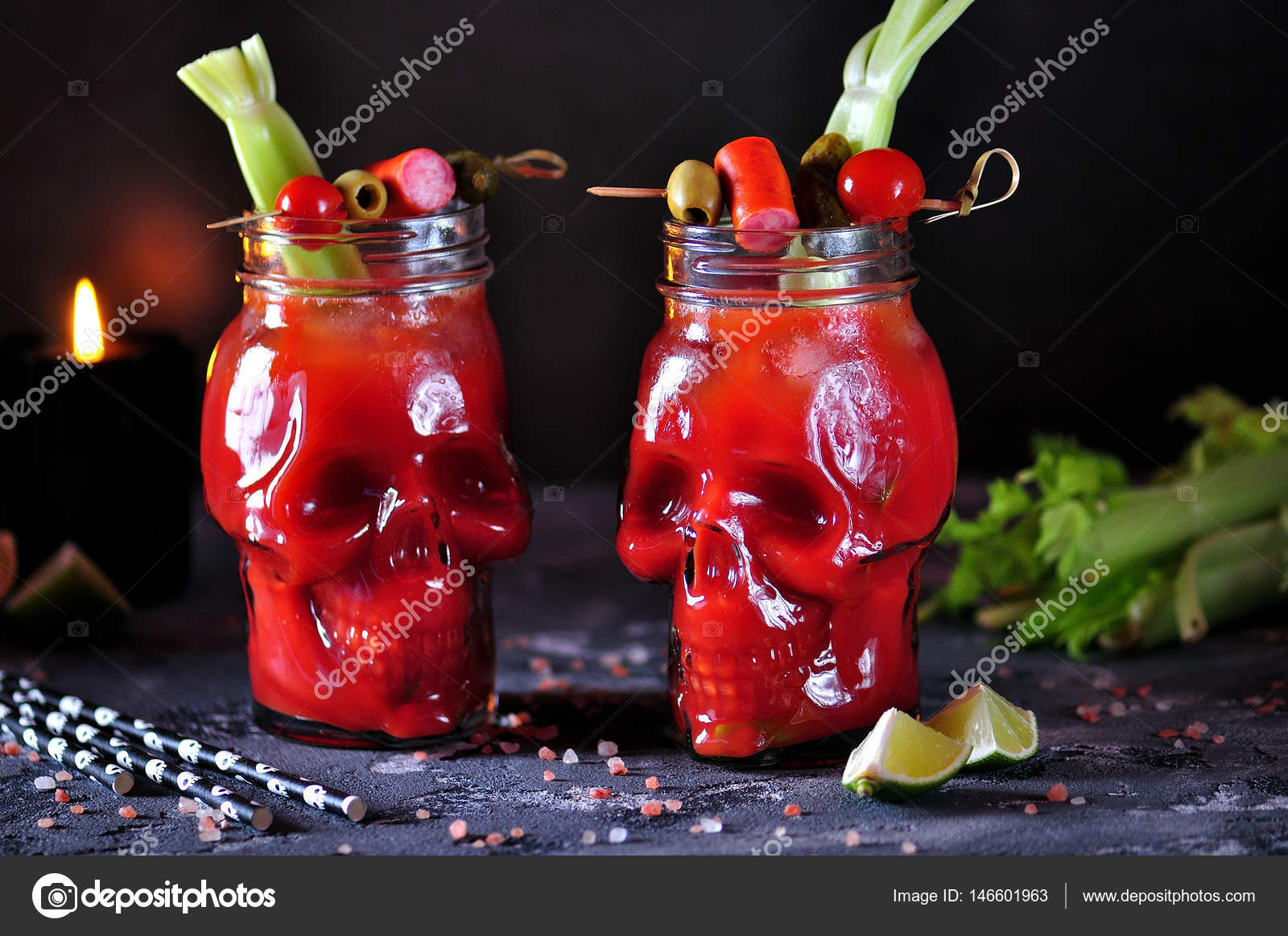 Bloody Mary cocktail in glasses-skull with celery sticks, pink salt, lime  and canapes from canned vegetables. Stock Photo by ©chudo2307 146601963