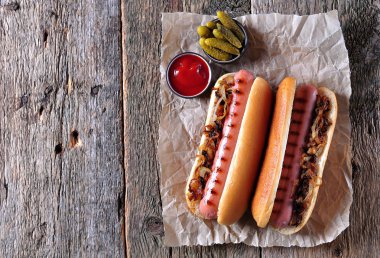 Çıtır soğan ve ketçap ile iki sosisli sandviç.