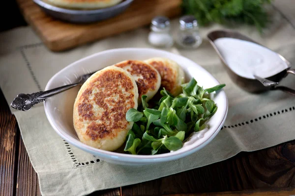 Картофельные торты с сыром, йогуртовым соусом и листом салата . — стоковое фото