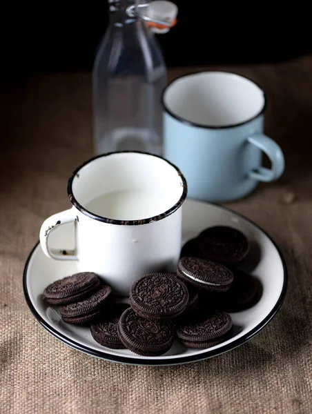 Cup of milk with chocolate cookies.Rustic style. — Stock Photo, Image