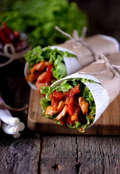 Fajitas med kyckling, paprika, lök i en kryddig tomatsås, serveras i en tortilla. — Stockfoto