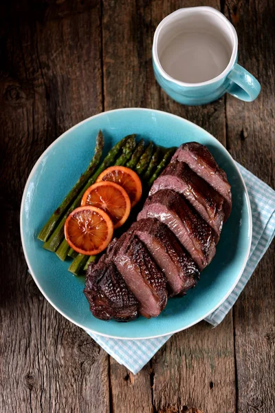 Duck breast baked in orange-honey sauce with asparagus. Rustic style. — Stock Photo, Image