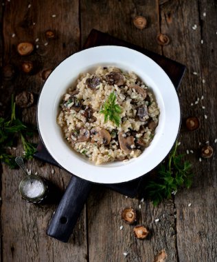 Eski bir ahşap zemin üzerine mantarlı risotto. Rustik tarzı.