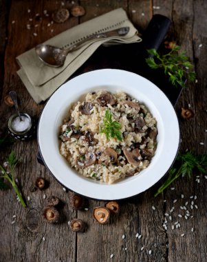 Eski bir ahşap zemin üzerine mantarlı risotto. Rustik tarzı.