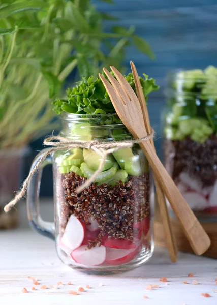 Здоровый салат с киноа, авокадо, огурцом и редиской с листьями салата и оливковым маслом . — стоковое фото