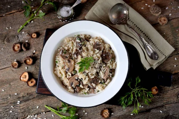 Risotto with mushrooms on an old wooden background. Rustic style. — Stock Photo, Image