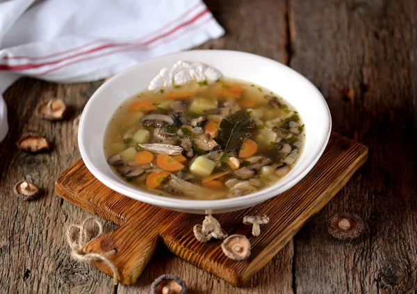 Грибной суп с картошкой, морковью, луком и куриным мясом на старом деревянном фоне. Сельский стиль . — стоковое фото
