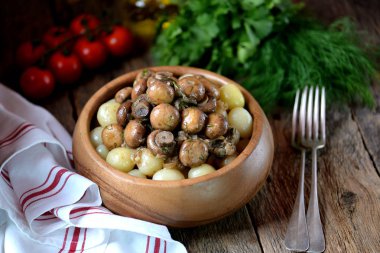 Soğan, sarımsak ve ahşap kase haşlanmış patates ile dereotu ile tüm mantar kızarmış. Rustik tarzı. Ahşap arka plan.