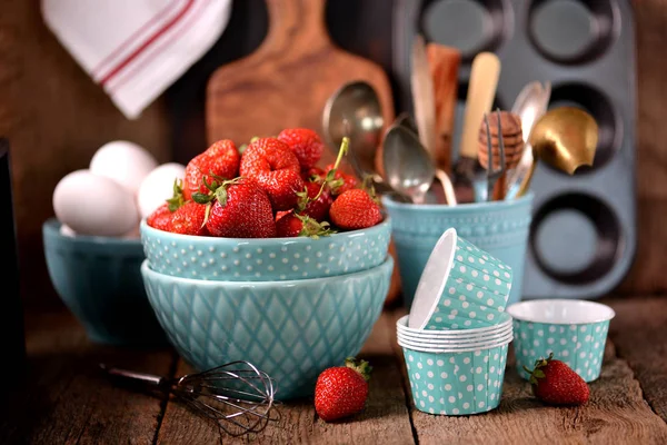 Αξεσουάρ κουζίνας για μαγείρεμα muffins, οργανικά φράουλες και τα αυγά σε ένα παλιό ξύλινο φόντο. Ρουστίκ στυλ. — Φωτογραφία Αρχείου