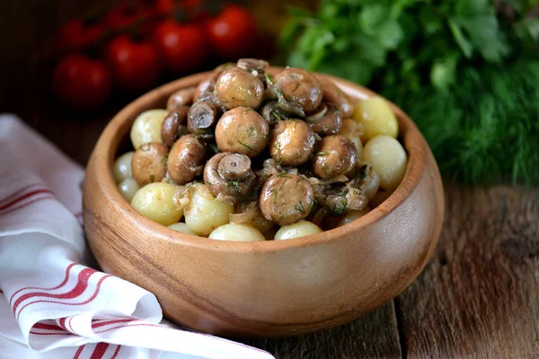 Cogumelos inteiros fritos com cebola, alho e endro em uma tigela de madeira com batatas cozidas. Estilo rústico. Fundo de madeira . — Fotografia de Stock