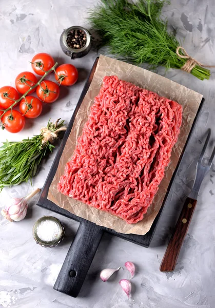 Carne fresca crua picada com alecrim, endro, alho e tomate cereja em um fundo de madeira velho. Espaço de cópia , — Fotografia de Stock