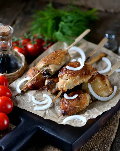 Heerlijke kip kebab op houten spiesen op de oude houten achtergrond. — Stockfoto