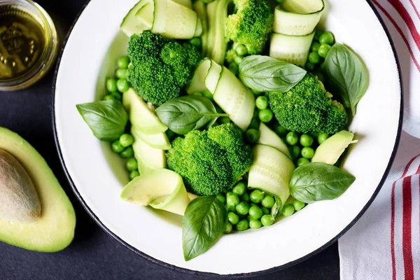 Gesunder Salat aus Brokkoli, grünen Erbsen, Gurken und Avocado mit Basilikum und Olivenöl. gesunde Ernährung. — Stockfoto