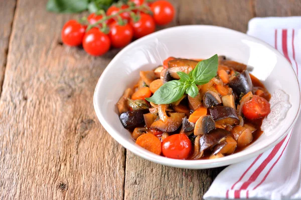 Auberginen geschmort mit Champignons, Zwiebeln, Kirschtomaten, Knoblauch und Basilikumblatt. rustikaler Stil. — Stockfoto