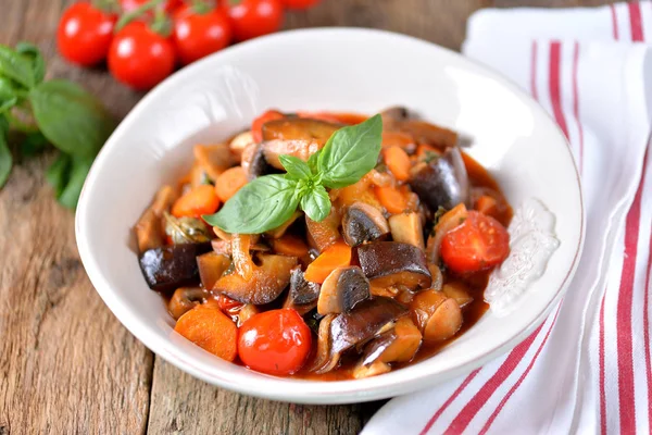 Aubergine gestoofd met ui, cherry tomaat, paddestoel, knoflook en basilicum blad. Rustieke stijl. — Stockfoto