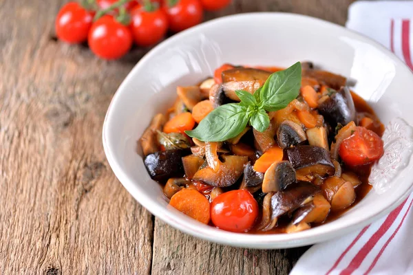 Aubergine gestoofd met ui, cherry tomaat, paddestoel, knoflook en basilicum blad. Rustieke stijl. — Stockfoto