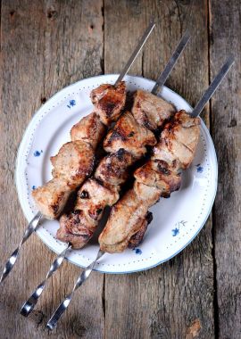 Domuz etinin şiş ile turşu soğan ve maydanoz eski bir ahşap zemin üzerine eve şiş kebap.