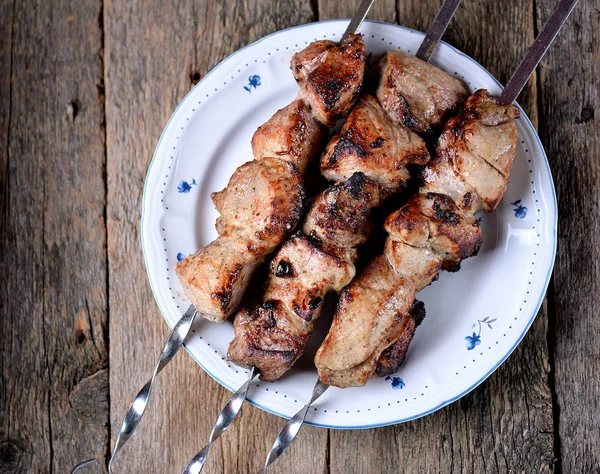 Accueil shish kebab de porc sur brochettes avec oignon mariné et persil sur un vieux fond en bois . — Photo