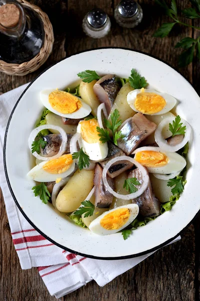Салат из легкой сельди, вареной картошки, яиц и лука с оливковым маслом и лимонным соком. Сельский стиль . — стоковое фото