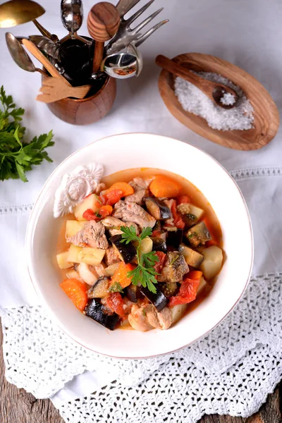 Fläsk gryta med aubergine, tomat, lök, potatis, morötter, vitlök och persilja. — Stockfoto