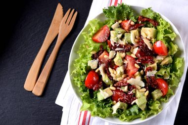 Salata marul, domates, kurutulmuş domates, avokado, parmesan, çam fıstığı zeytinyağı ile üzerinden. Sağlıklı gıda.