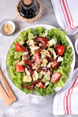 Salata marul, domates, kurutulmuş domates, avokado, parmesan, çam fıstığı zeytinyağı ile üzerinden. Sağlıklı gıda.