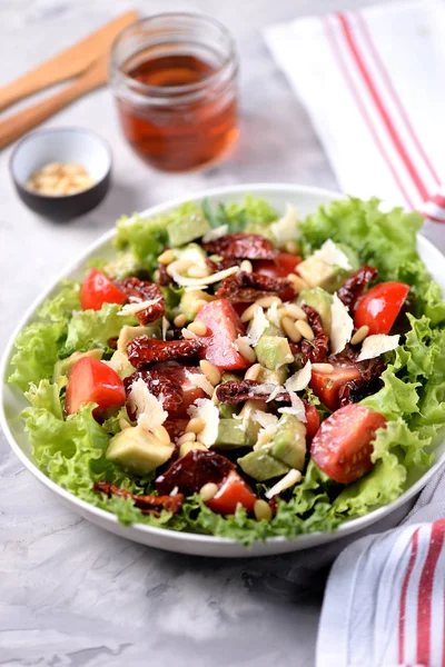 Salată din salată verde, roșii cherry, roșii uscate, avocado, parmezan, nuci de pin cu ulei de măsline. Alimente sănătoase . — Fotografie, imagine de stoc