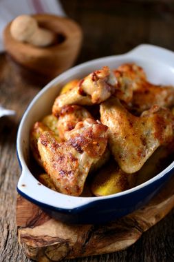 Baharatlar ve aromatik otlar - fesleğen, biberiye, dereotu ve sarımsaklı patates ile pişmiş tavuk kanadı.