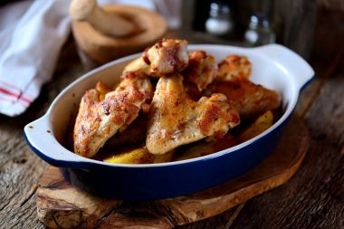 Baharatlar ve aromatik otlar - fesleğen, biberiye, dereotu ve sarımsaklı patates ile pişmiş tavuk kanadı.