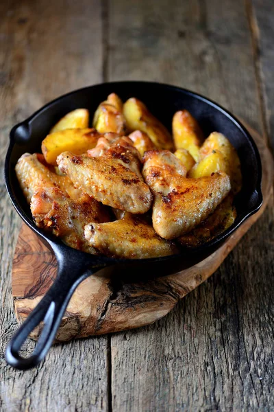 Kuřecí křidélka pečená s bramborem v koření a aromatických bylinek - bazalka, rozmarýn, koprem a česnekem. — Stock fotografie