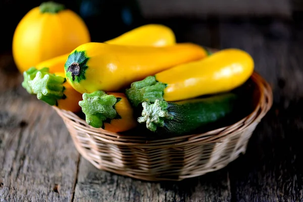 Organic yellow and green zucchini on an old wooden background. — Stock Photo, Image