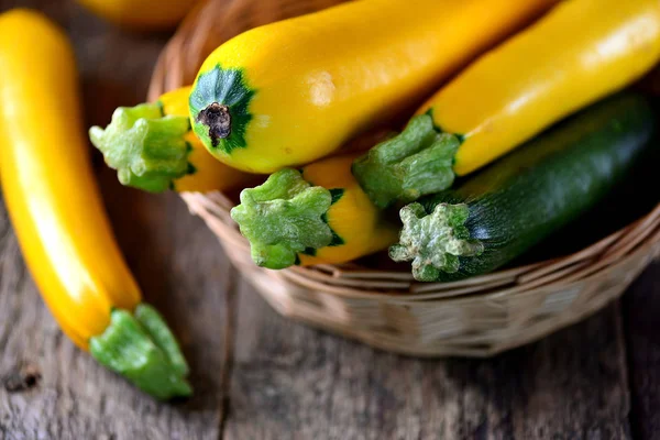 Organic yellow and green zucchini on an old wooden background. — Stock Photo, Image
