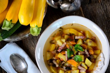 Patates, havuç, soğan, mantar, maydanoz ve pastırma eski bir ahşap zemin üzerine sarı kabak çorbası.