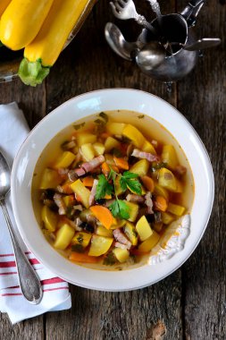 Patates, havuç, soğan, mantar, maydanoz ve pastırma eski bir ahşap zemin üzerine sarı kabak çorbası.