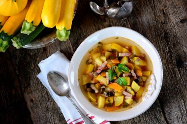 Patates, havuç, soğan, mantar, maydanoz ve pastırma eski bir ahşap zemin üzerine sarı kabak çorbası.