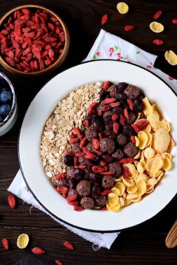 Mısır gevreği, çikolata topları, yulaf ezmesi, goji meyveleri ve taze yaban mersini sağlıklı kahvaltı.