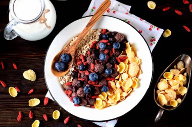 Mısır gevreği, çikolata topları, yulaf ezmesi, goji meyveleri ve taze yaban mersini sağlıklı kahvaltı.