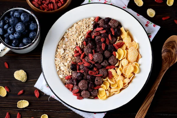 Mısır gevreği, çikolata topları, yulaf ezmesi, goji meyveleri ve taze yaban mersini sağlıklı kahvaltı.