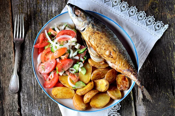 Mackerel baked with baby potatoes, rosemary, dill and parsley, sweet onions and spices. Served with a salad of fresh vegetables - tomatoes, cucumbers, sweet onions, dill, parsley and olive oil. — Stock Photo, Image