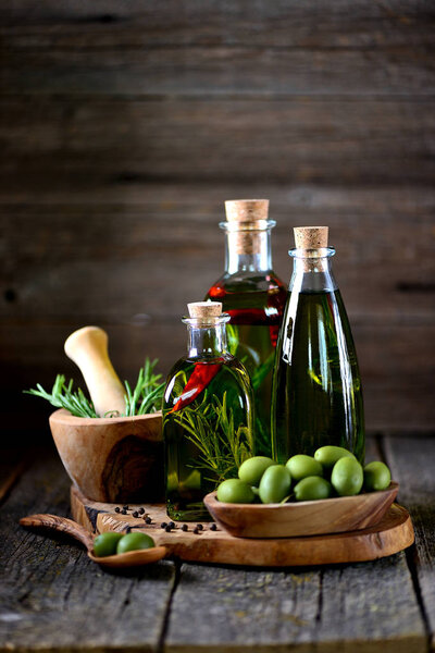 Органическое оливковое масло со специями и травами на старом деревянном фоне. Здоровое питание
.