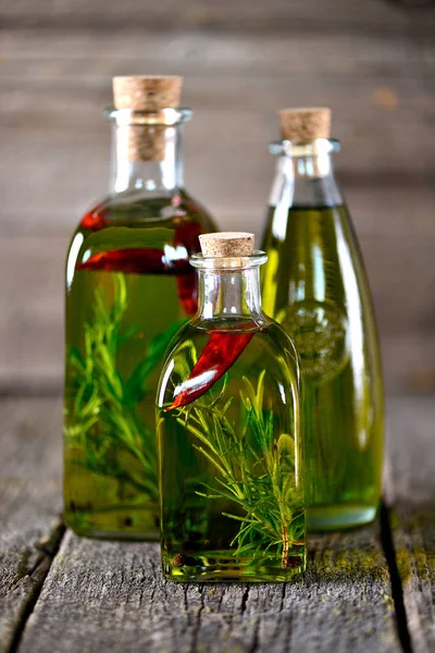 Organic olive oil with spices and herbs on an old wooden background. Healthy food. — Stock Photo, Image