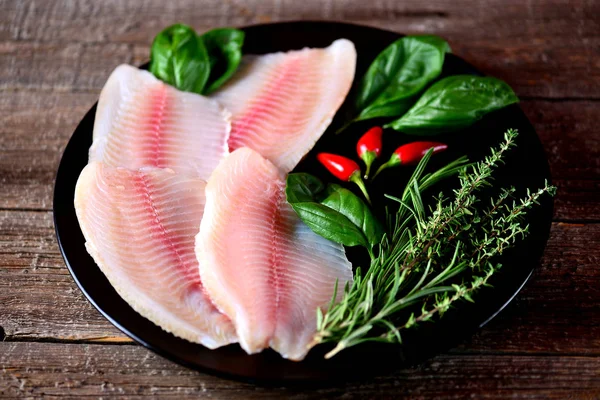 Kekik, biberiye, fesleğen ve biber tilapia balık taze çiğ fileto.