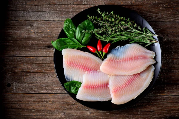 Kekik, biberiye, fesleğen ve biber tilapia balık taze çiğ fileto. Üstten Görünüm. Kopya alanı. 