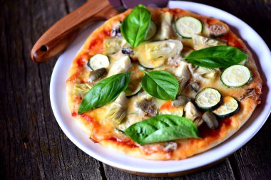 Sağlıklı vejetaryen pizza Mısır unu enginar, kabak, mozzarella, mavi peynir, Kapari Karpuzu ve organik fesleğen ile yapılmış. Sağlıklı gıda.