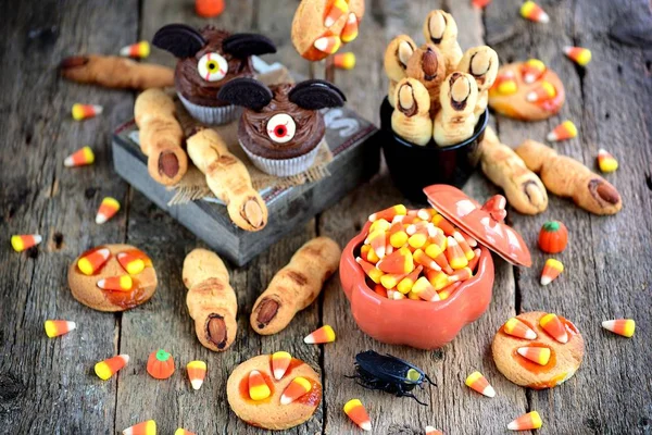 Cupcake al cioccolato "pipistrelli" e biscotti frolla "dita di strega" - deliziosi dolci da forno per la celebrazione di Halloween . — Foto Stock