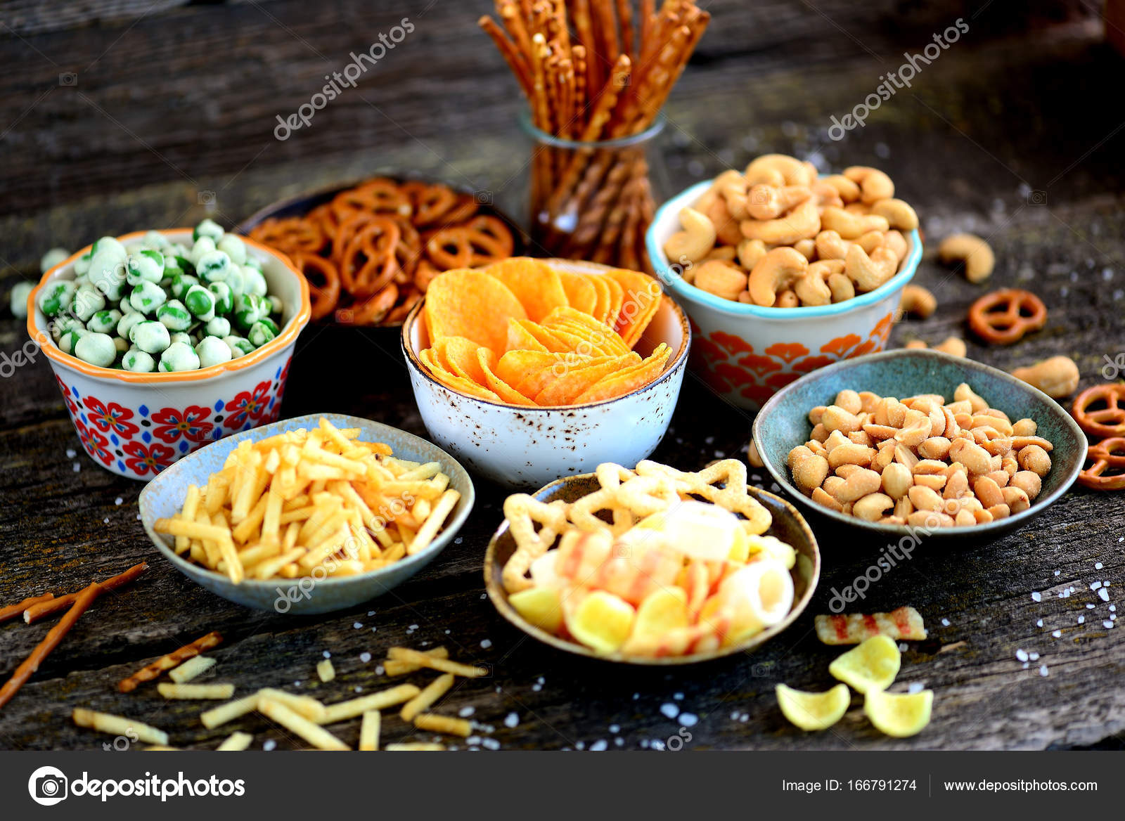 Diferentes tipos de bocadillos papas fritas, cacahuetes salados