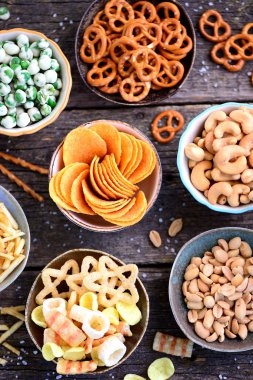 Aperatifler - cips, tuzlu fıstık, kaju fıstığı, wasabi ile bezelye, tuz, patates ile simit çeşitleri saman tuzlu.