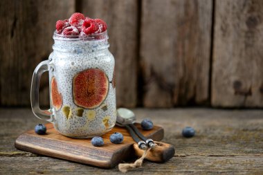 Sağlıklı kahvaltı chia tohum, agave şurubu, süt, incir ve Dondurulmuş çilek, ahududu ve yaban mersini ile pudingim. Kopya alanı.