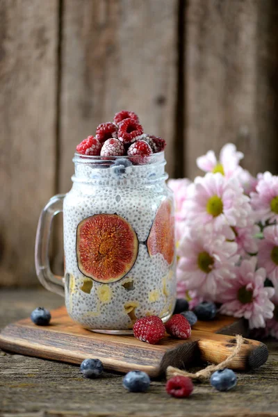 Healthy breakfast is pudding with chia seeds, agave syrup, milk, figs and frozen berries of raspberries and blueberries. — Stock Photo, Image